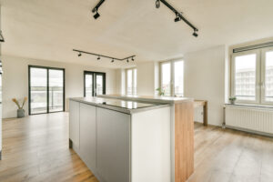 Stylish and spacious apartment interior featuring large windows, wooden flooring, and modern design elements that create a welcoming atmosphere.